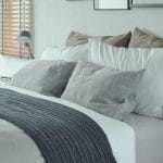 Dark gray bed runner with gray and brown pillows on bed Slaapkamer - Dexitex